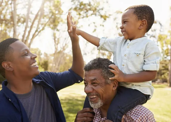 Grandfather With Son And Grandson Having Fun In Park
